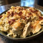 A close-up of a bowl filled with creamy Chicken Bacon Ranch Casserole, topped with crispy bacon and melted cheese.