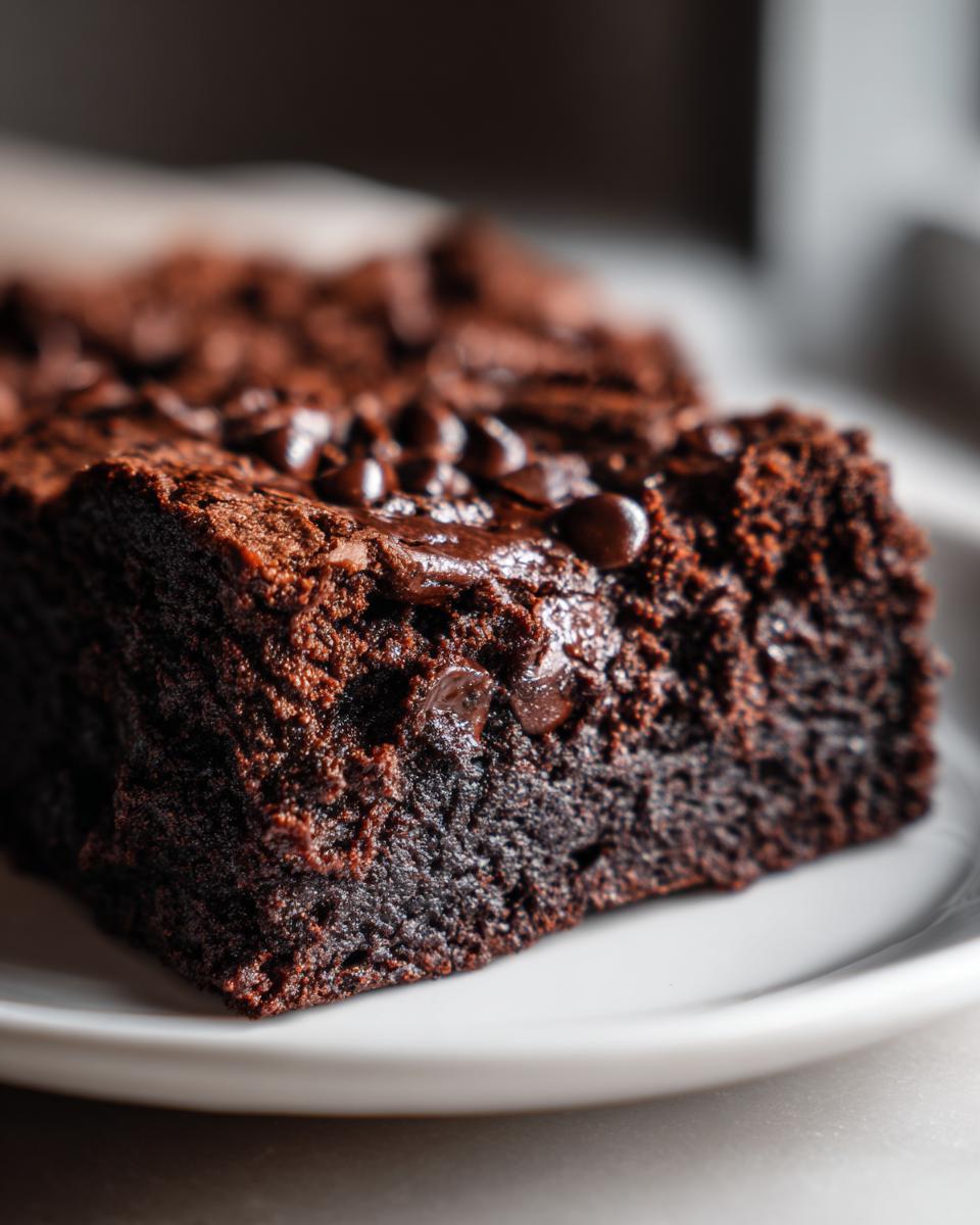 Close-up of a rich chocolate brownie topped with melted chocolate chips, a Cottage Cheese Microwave Brownie.