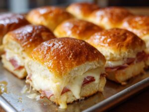 Close-up of delicious Ham and Cheese Sliders with melted cheese oozing out.
