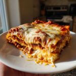 A mouthwatering slice of Lasagna with Cottage Cheese, showcasing layers of pasta, meat sauce, and melted cheese.