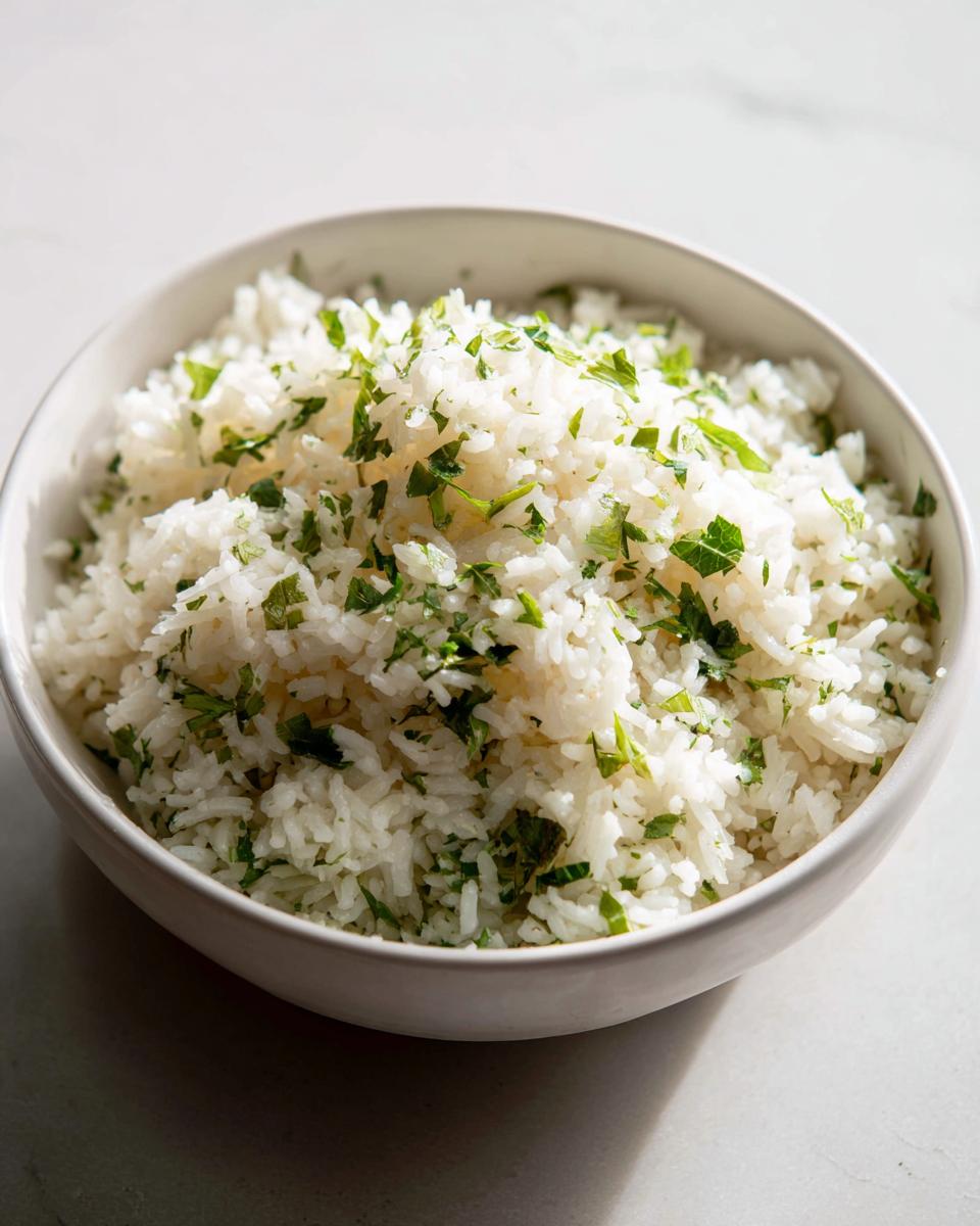 A white bowl filled with fluffy Mediterranean lemon rice, generously topped with fresh chopped parsley.