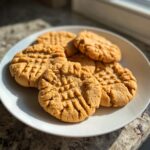 A plate full of delicious peanut butter cookies with classic criss-cross fork marks.