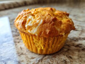 Close-up of a delicious Starbucks pumpkin cream cheese muffin with a golden-brown top and visible cream cheese swirls.