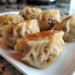 A close-up of golden-brown pan-fried Traditional Chinese Dumplings filled with savory meat.