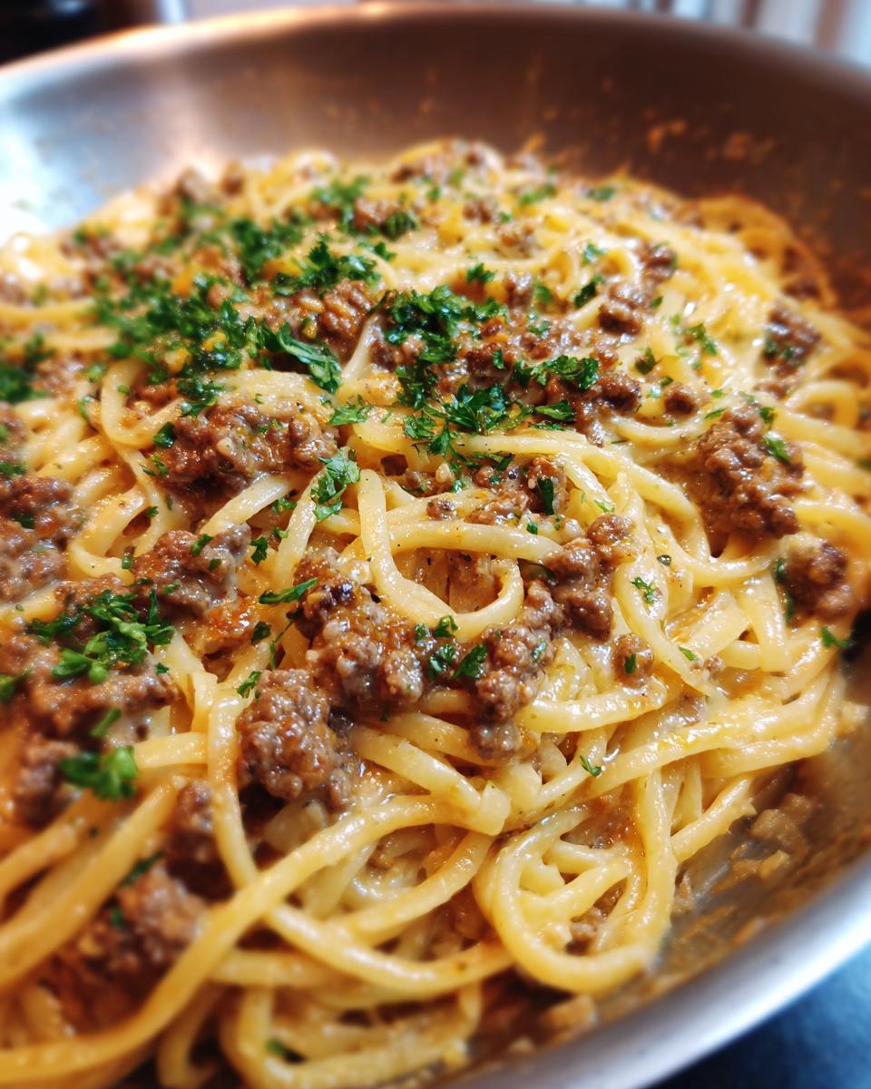 Close-up of a pan filled with Beef and Garlic Butter Linguine, garnished with fresh parsley.