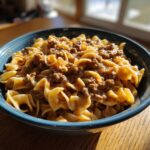A close-up shot of a bowl filled with delicious beef and noodles, coated in a savory sauce.