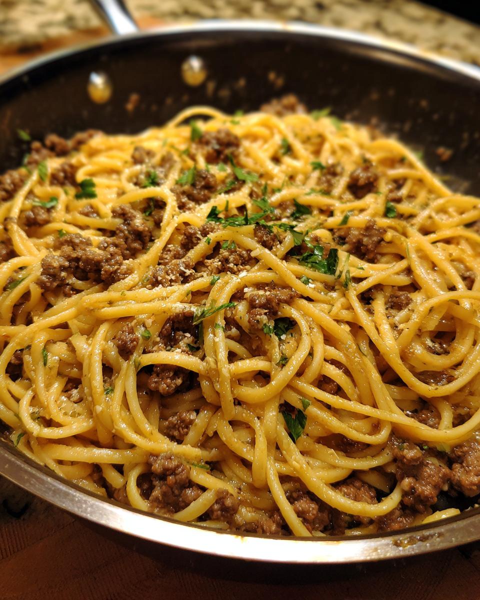 Close-up of Beef and Garlic Butter Linguine in a skillet, garnished with parsley.