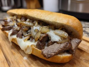 A close-up view of a mouthwatering Philly cheesesteak sandwich filled with thinly sliced steak, caramelized onions, and melted cheese.