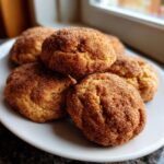 Close-up of a stack of freshly baked pumpkin snickerdoodle cookies, coated in cinnamon sugar.