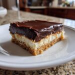 A single slice of Chocolate Dream Bars featuring a graham cracker crust, creamy filling, and rich chocolate topping.