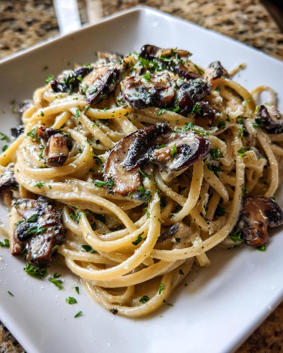 Close-up of creamy mushroom pasta tossed with sautéed mushrooms and garnished with fresh parsley.