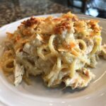 A close-up of a cheesy, creamy serving of monterey chicken spaghetti with a golden-brown baked topping.