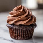 A single, perfectly baked easy chocolate cupcake topped with rich, swirled chocolate frosting.