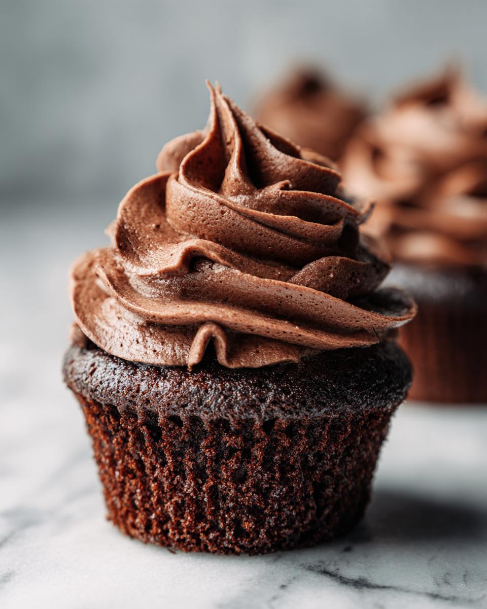 Close-up of a decadent easy chocolate cupcake topped with swirls of rich chocolate frosting.