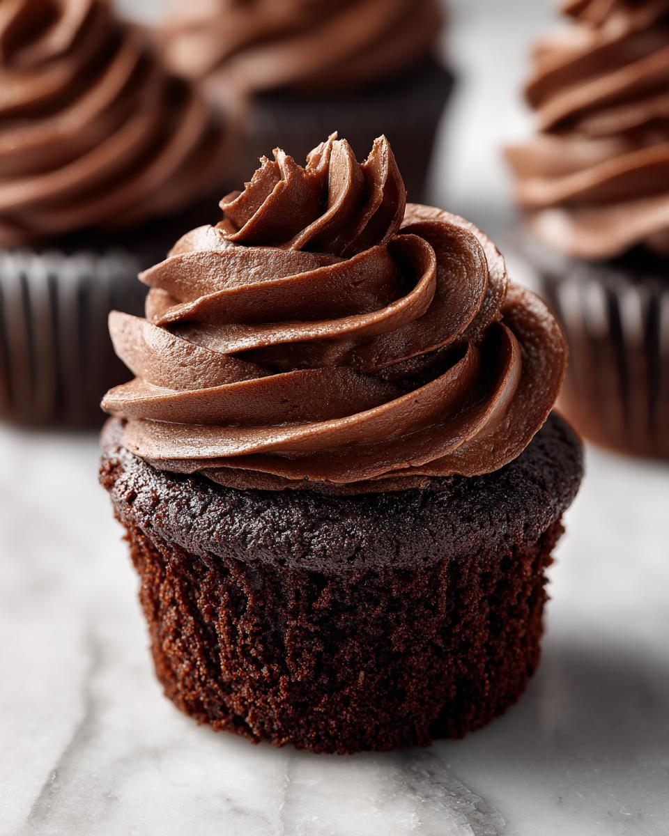 Close-up of a decadent easy chocolate cupcake topped with swirls of rich chocolate frosting.