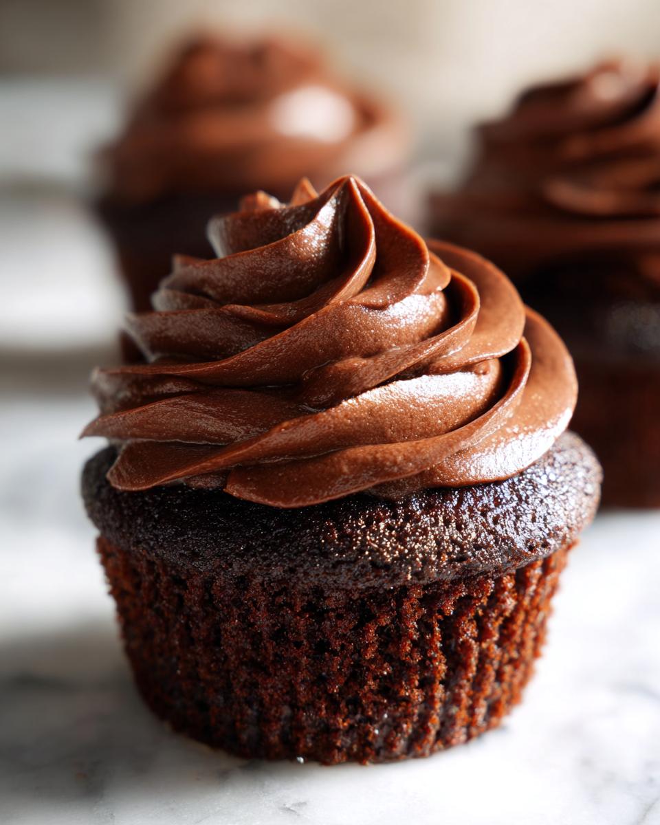 Close-up of a decadent easy chocolate cupcake topped with swirls of rich chocolate frosting.