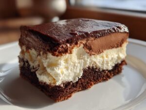 A rich slice of Italian love cake featuring a dark chocolate base, thick white cream layer, and chocolate mousse topped with ganache.