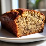 Close-up of a moist slice of golden brown sugar free banana bread showing the speckled interior texture.