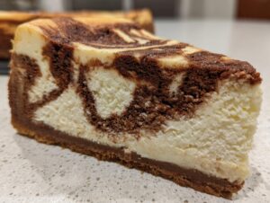 Close-up of a rich slice of snickerdoodle cheesecake featuring a beautiful chocolate swirl pattern.