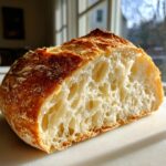 Close-up cross-section showing the open, airy crumb structure of homemade artisan bread.