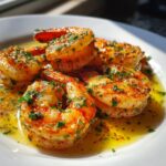 Close-up of juicy Cajun shrimp coated in spices and fresh parsley, swimming in a pool of garlic butter sauce.