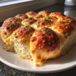Close-up of cheesy Hawaiian roll garlic bread, baked until golden brown and garnished with parsley.