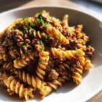 Close-up of creamy beef pasta made with fusilli noodles, topped with fresh parsley.