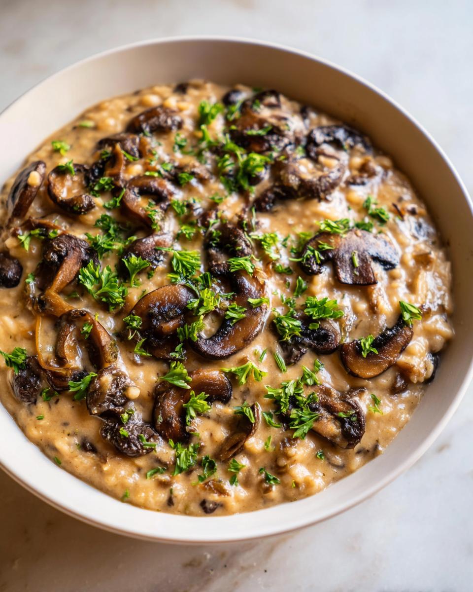 A close-up of creamy white bean mushroom stew, rich with sautéed mushrooms and fresh parsley garnish.