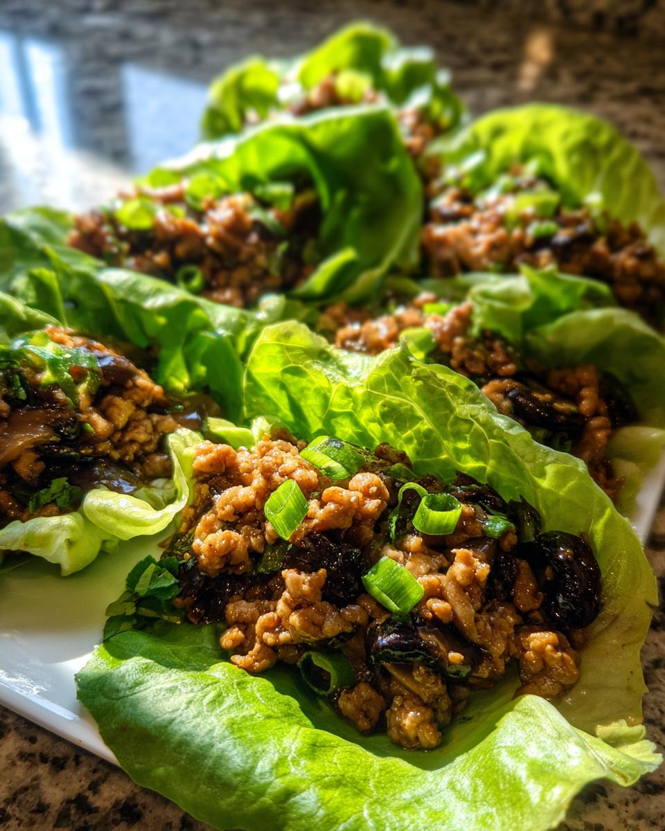 Several bright green lettuce cups filled with savory ground chicken mixture for amazing chicken lettuce wraps.