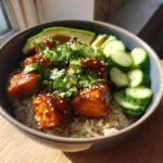 Close-up of a delicious salmon bowls featuring glazed salmon cubes over brown rice, topped with cilantro and sesame seeds.