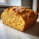 A close-up view showing the golden, textured crumb of the freshly baked 4 ingredient soda bread.