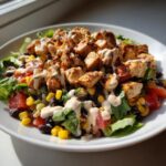 A vibrant southwest chicken salad featuring grilled chicken, black beans, corn, tomatoes, and a creamy dressing.