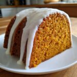 A thick slice of moist sweet potato pound cake topped with thick white vanilla glaze.