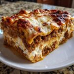A close-up of a thick, cheesy slice of amazing 1-layer lasagna with browned cheese topping.
