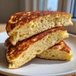 Close-up cross-section showing the fluffy, airy texture inside three stacked coconut flour pancakes.