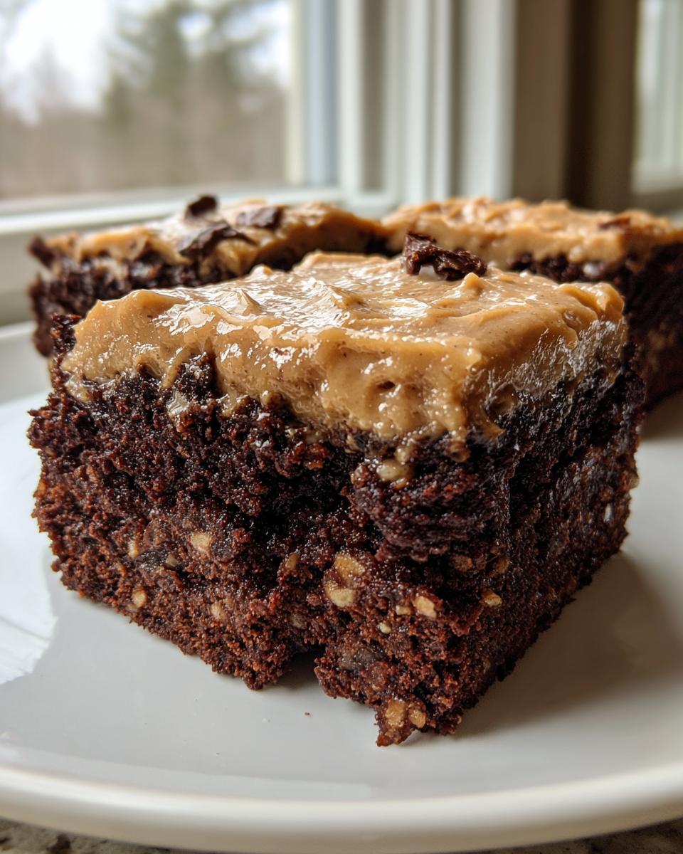 Close-up of a rich, fudgy banana bread brownies square topped with thick peanut butter frosting.