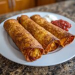 Three crispy, golden-brown potato tacos filled with seasoned potato mixture, served with salsa and sour cream.