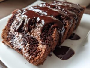 Close-up of sliced hot fudge brownie bread drizzled generously with dark chocolate fudge sauce.