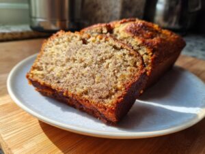 Two slices of moist sourdough banana bread displayed on a light blue plate, showing the rich crumb texture.