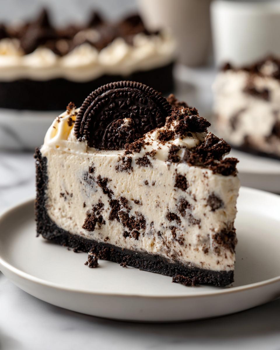 A close-up slice of no bake oreo pie featuring a thick, creamy filling loaded with cookie pieces and a dark crust, topped with whipped cream and a whole Oreo.