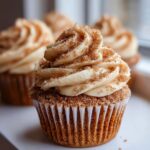 Close-up of a single churro cupcake topped with cinnamon-sugar frosting and extra cinnamon-sugar sprinkles.