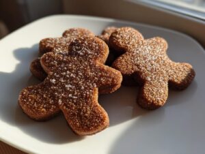 Close-up of several soft gingerbread cookies shaped like people, dusted with coarse sugar.