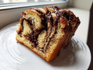 Close-up of two thick slices of rich chocolate babka showing the swirled, gooey filling.