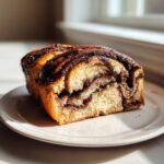 A close-up, cross-section view of a freshly baked chocolate babka loaf showing rich swirls of filling.